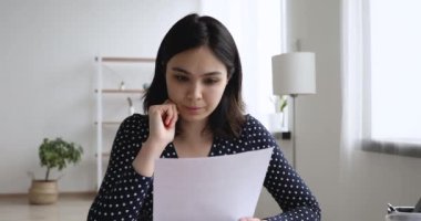 Asyalı öğrenci kız kompozisyon okuyup düzeltmeler üzerinde kafa yoruyor.