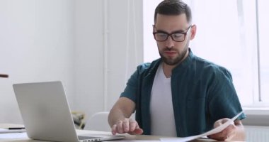 Laptop üzerinde çalışan odaklanmış girişimci ofis masasında oturuyor.