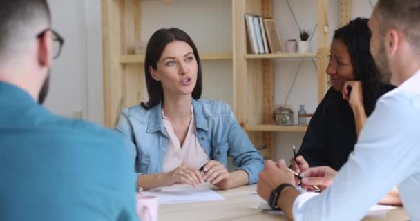 Zelfverzekerde vrouwelijke bedrijfsleider praat met diverse partners aan tafel — Stockvideo