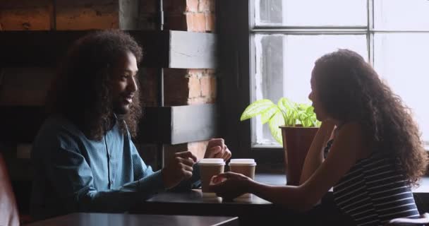 Happy african woman and man talking relaxing at coffeehouse table — Stock Video