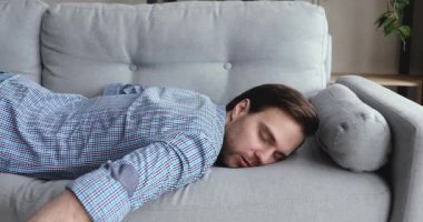 Yorgun bir adam işten sonra kanepeye yığılıp eve geldi.