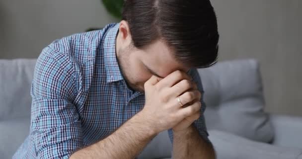 Muž sedí na pohovce cítí nešťastný kvůli osobním problémům — Stock video