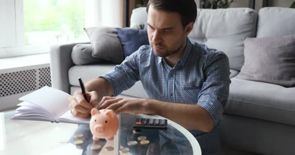 Man beräknar och skriver ner kostnader i daglig planerare — Stockvideo