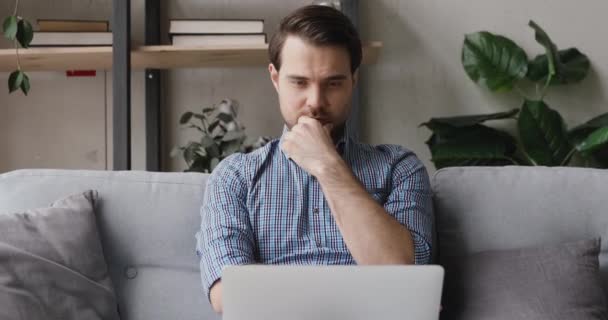 Konzentrierter Mann mit Laptop überlegt, entscheidet, von zu Hause aus zu arbeiten — Stockvideo