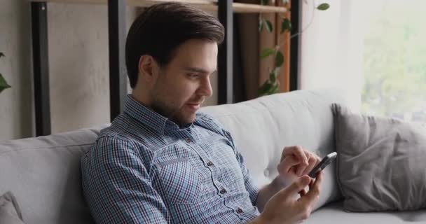 Человек, держащий смартфон получил хорошие новости от смс чувствует себя счастливым — стоковое видео