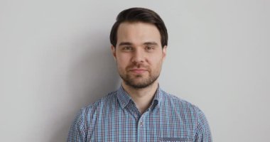 Gri stüdyonun arka planındaki portre pozitif gülümseyen çekici bir adam.