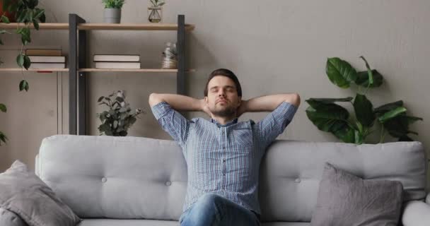 Muž odpočívající na gauči dal ruce za hlavu cítí klidný — Stock video