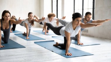 İçeride parsva balasana yapan aktif çok ırklı insanlar..