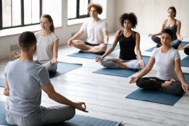 Genç erkek eğitmen, çok ırklı öğrenciler için yüksek lisans yapıyor..