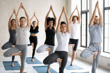 Genç, profesyonel Hintli kadın etnik köken eğitmeni yoga mastırı sınıfında..