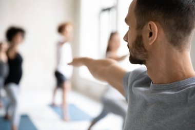 Yoga erkek eğitmeni bir grup öğrenciye master dersi veriyor..
