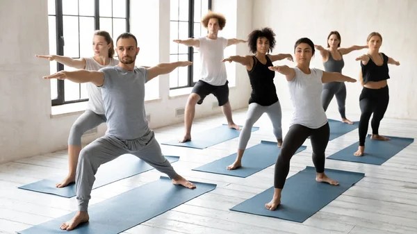 为集中的多种族学生开办瑜伽课的年轻男性教练. — 图库照片