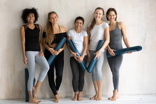 喜形于色的年轻混合型女子瑜伽教练站在墙边. — 图库照片