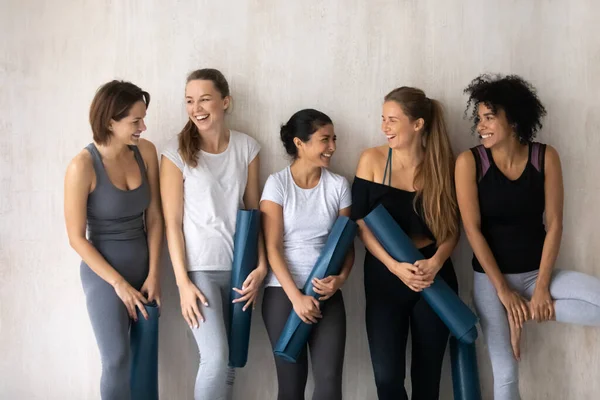 Happy young mixed race female friends enjoying communicating indoors. — Stock Photo, Image