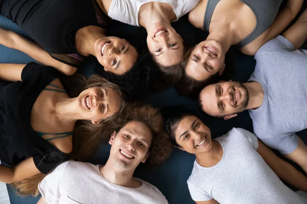 Young mixed race happy people lying on floor in circle. — Stock Photo, Image