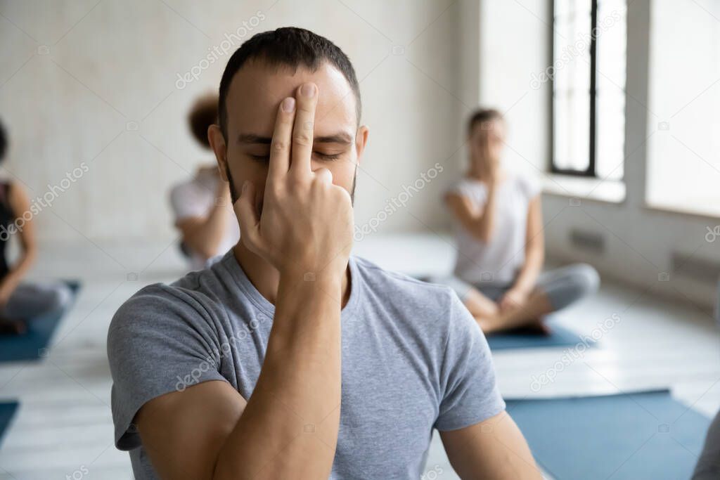 Mindful young man practicing Alternate Nostril Breathing.