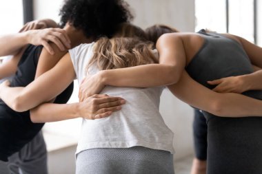 Çoklu etnik çeşitliliğe sahip bir grup sporcu motivasyon konuşması yapıyor..