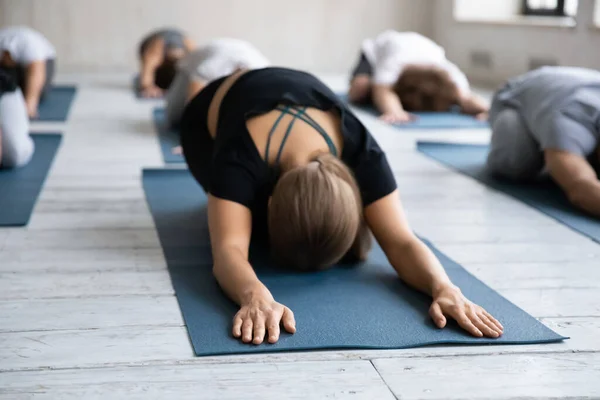 Kvinnlig tränare visar barn reparativ pose på golvmattan. — Stockfoto