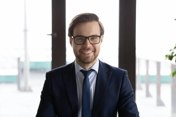 Profile picture of smiling Caucasian businessman in glasses at workplace — Stock Photo, Image