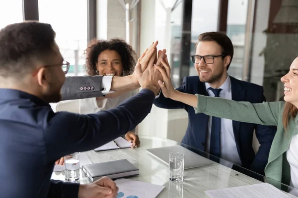 Emocionados empleados multiétnicos dan cinco en la reunión — Foto de Stock