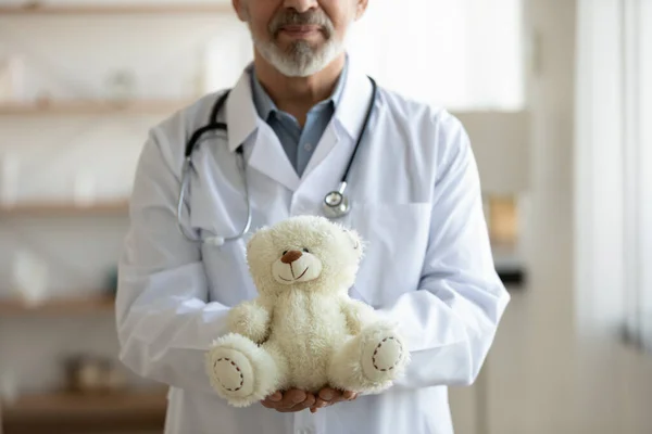 Närbild av äldre manliga barnläkare pose med fluffig leksak — Stockfoto