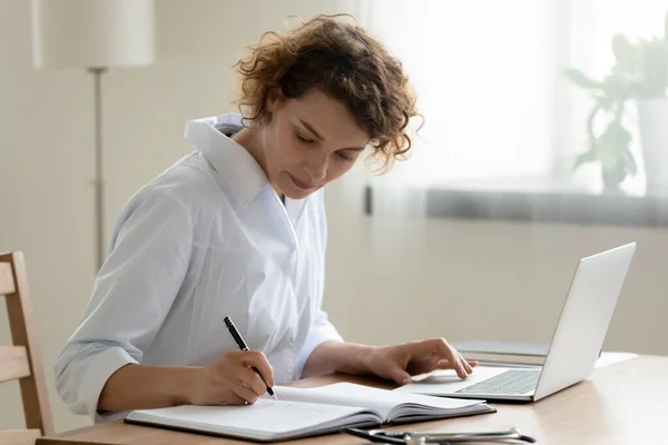 Female doctor work on laptop write in medical journal