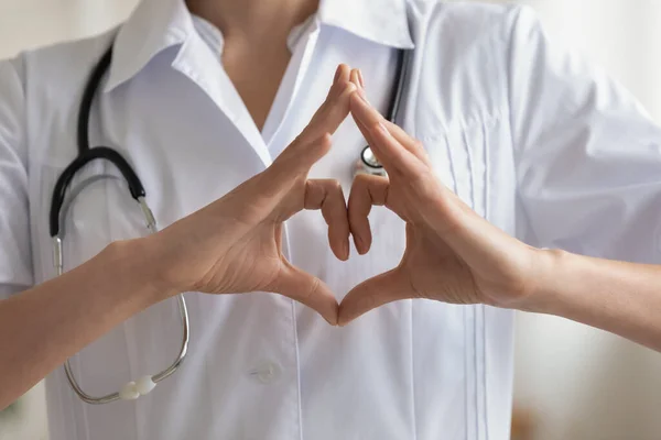 Close up of female doctor show heart sign with hands — Stock Photo, Image