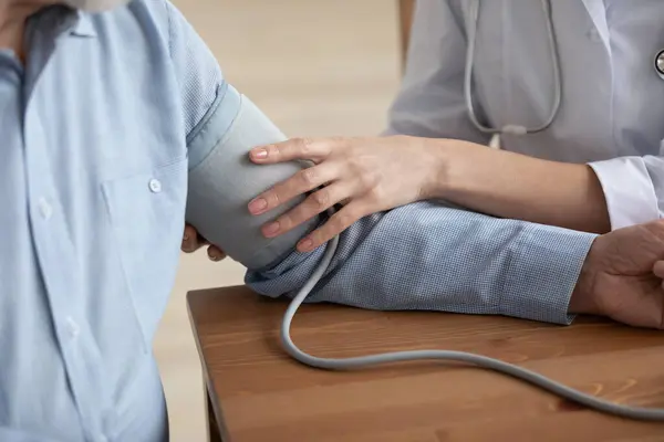 Close up of nurse measure blood pressure of elderly patient — Stock Photo, Image