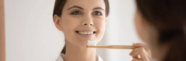 Head shot mirror reflection smiling woman holding eco toothbrush — Stock Photo, Image