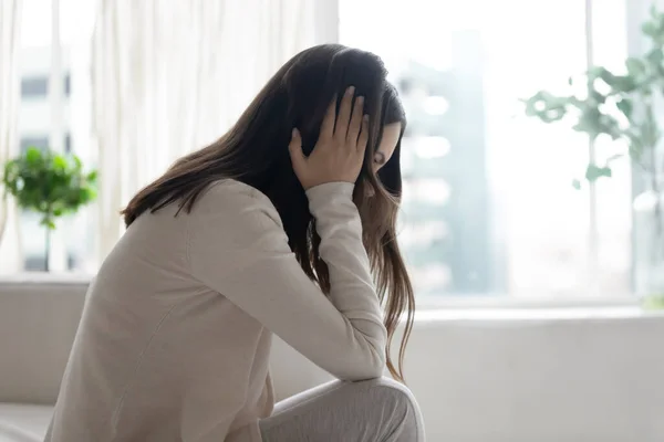 Несчастная депрессивная женщина сидит одна, думая о проблемах — стоковое фото