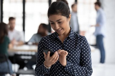 Hintli ofis çalışanı cep telefonu kontrol programı çalışma gününü kullanıyor