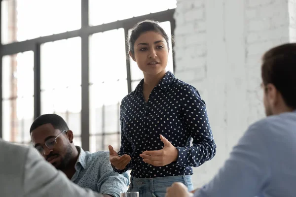 Indian businesswoman negotiates with clients during formal meeting