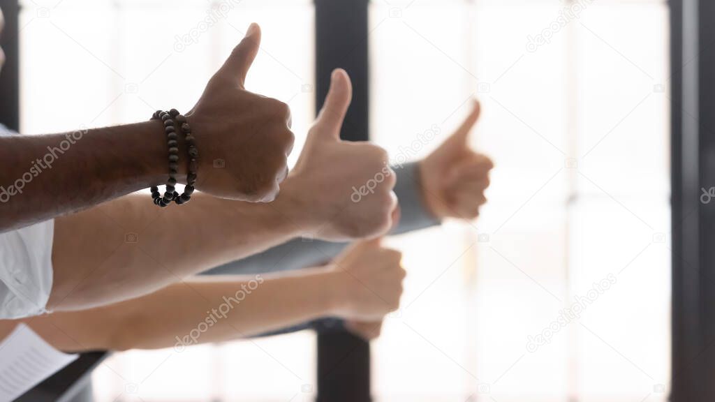 Hands of diverse people showing thumbs up closeup image