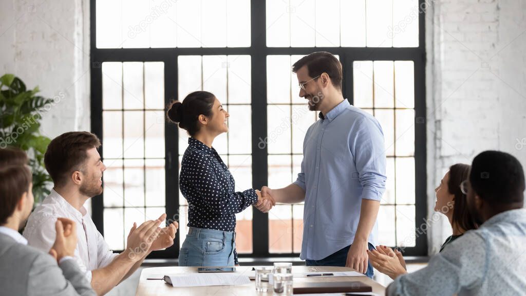 Indian and caucasian businesspeople handshake start negotiations at office boardroom