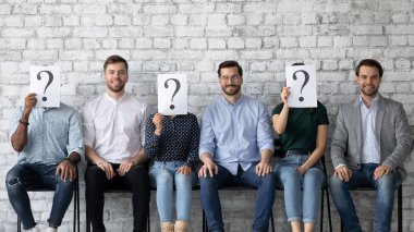 Üç başvuru sahibi yüzlerini kağıdın arkasına gizliyor.