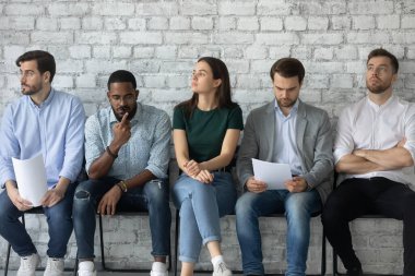 Bekleyen bir grup insan iş görüşmesinde gergin hissediyor.