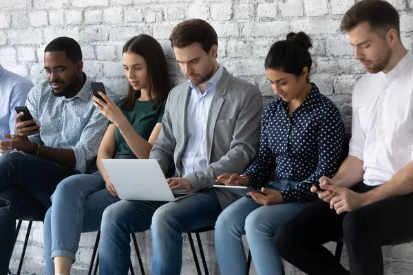 Multiracial applicants focused in gadgets while await for job interview — Stock Photo, Image