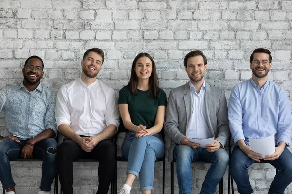 Cinco solicitantes multiétnicos esperan entrevista de trabajo sonriendo mirando a la cámara — Foto de Stock