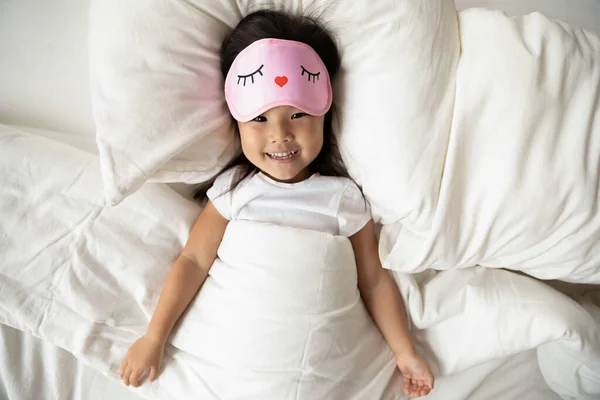 Sonriente joven vietnamita etnia pequeño bebé despertando en la cama . — Foto de Stock