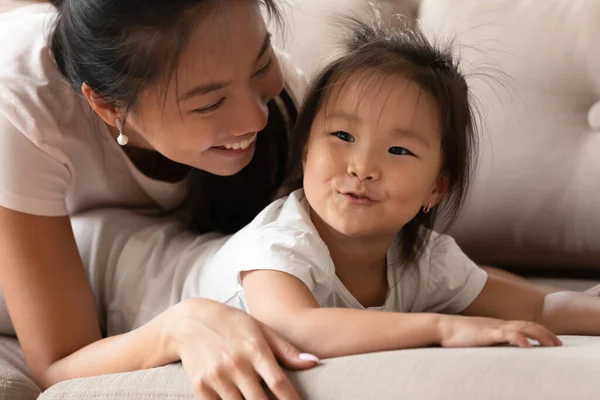 Boldog fiatal gondoskodó vietnámi anyuci ölelés vicces baba lány. — Stock Fotó