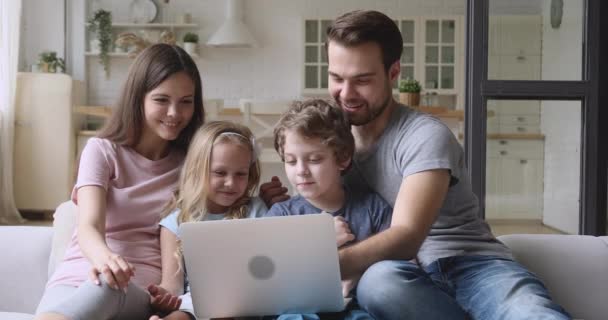 Φιλική ευτυχισμένη οικογένεια των τεσσάρων απολαμβάνουν τη χρήση φορητού υπολογιστή στο σπίτι — Αρχείο Βίντεο