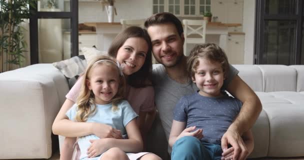 Família feliz com crianças pequenas se unindo rindo olhando para a câmera — Vídeo de Stock