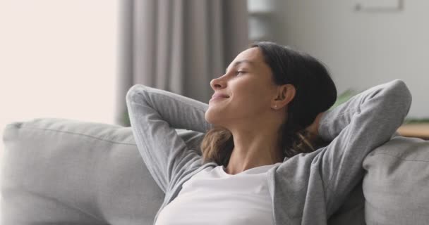 幸せなリラックスした女性の残りのラウンジでソファ楽しむ平和な一日 — ストック動画