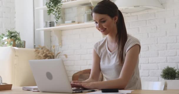 Overblij meisje student vieren online succes met behulp van laptop thuis — Stockvideo