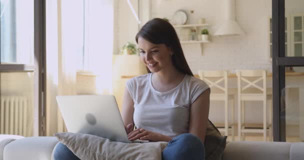Возбужденная молодая женщина с помощью ноутбука изумлен читать отличные онлайн новости — стоковое видео
