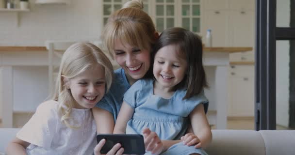 Ibu dan putri kecil yang bahagia tertawa menonton kartun di smartphone — Stok Video