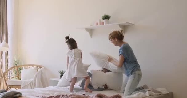 Mãe feliz e filhas crianças jogando travesseiro luta na cama — Vídeo de Stock