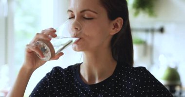 Bir bardak doğal su içen kadın susuzluğunu gideriyor.
