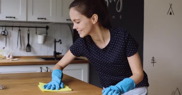 Домогосподарка носить гумові захисні рукавички очищає кухонний стіл — стокове відео