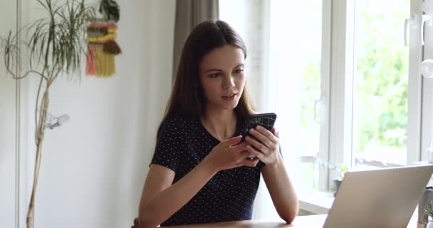 Девушка держит смартфон читает смс отвечая оставляет голосовое сообщение — стоковое видео